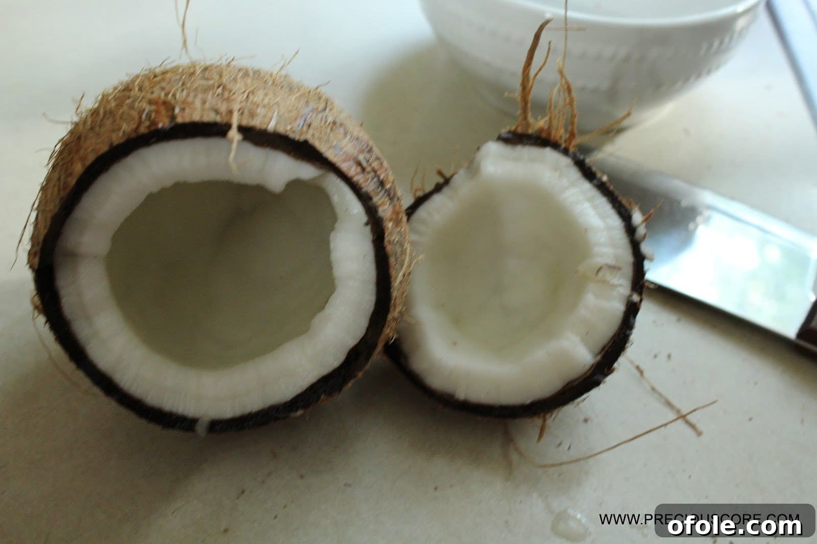 Breaking a whole coconut for fresh flakes