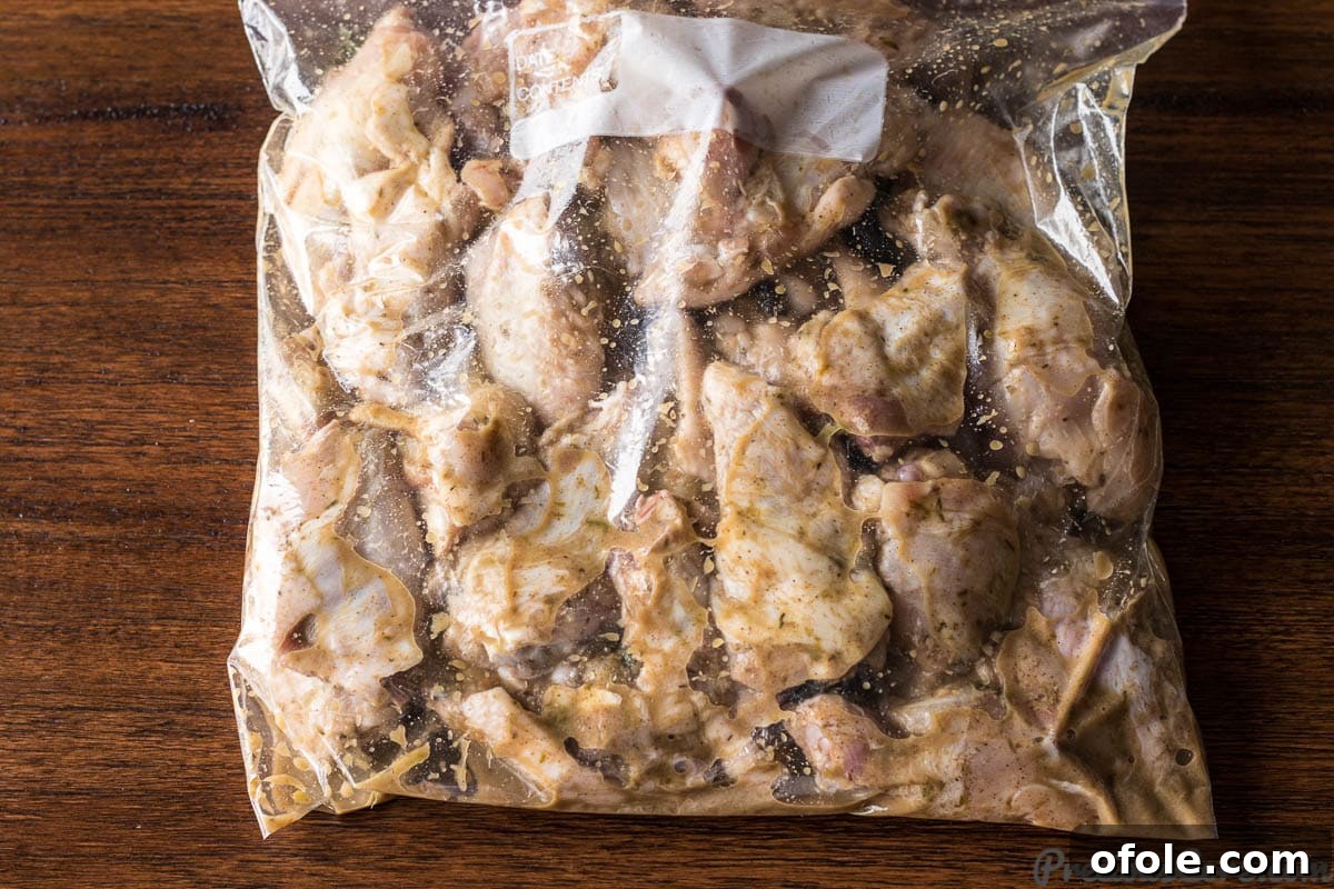 Chicken wings marinating in a homemade jerk sauce inside a clear plastic bag