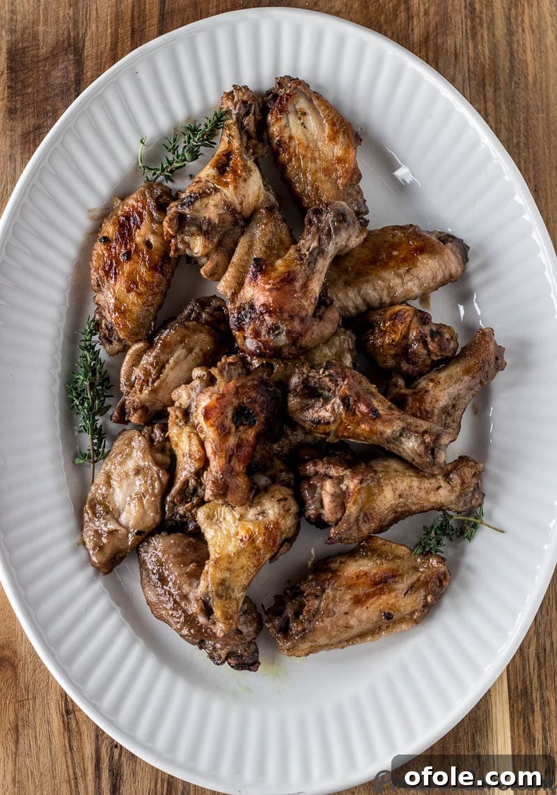 Crispy Jerk Chicken Wings served on a white serving tray, garnished with fresh herbs