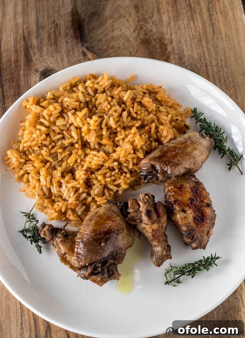 Jerk Chicken served on a plate with fluffy white rice as a side dish