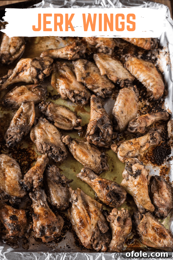 Close-up of golden-brown Jerk Chicken Wings on a tray, ready to be enjoyed