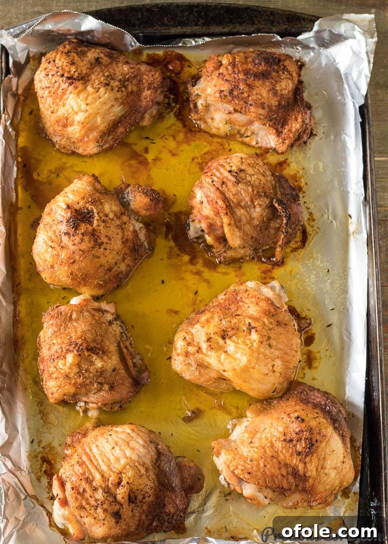 Golden Crispy Oven Chicken Thighs 5 just baked chicken thighs on a baking sheet