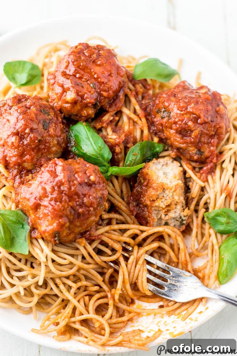 Savory Chicken Bites 5 A close-up shot of perfectly cooked chicken meatballs and spaghetti, generously coated in a rich, red tomato sauce, ready to be enjoyed.