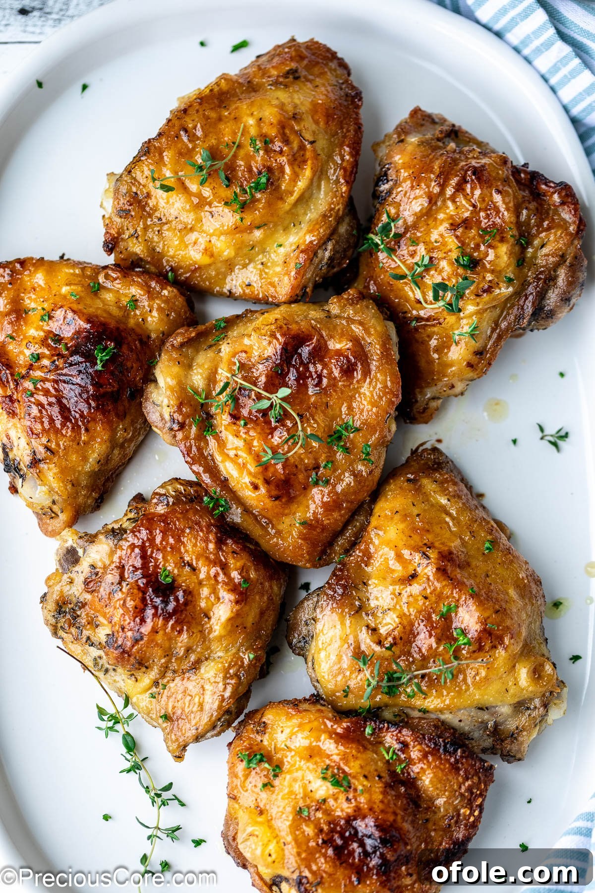 Mayonnaise chicken thighs garnished with fresh thyme on a white platter, ready to serve.