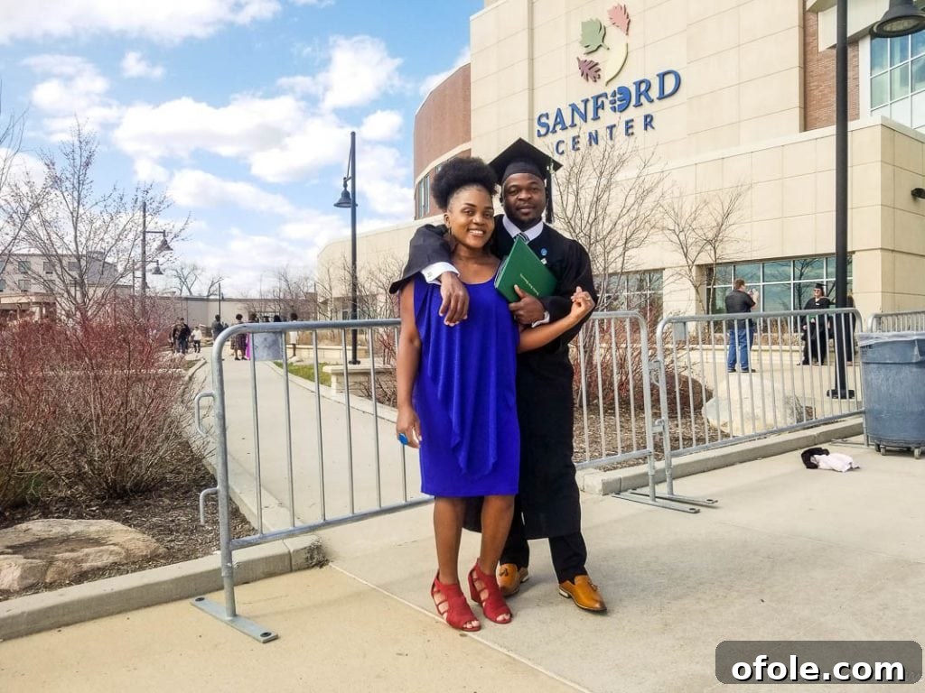 My Latest Chapter 4 Man in graduation gear with a woman in a blue dress in front of the Sanford Center.
