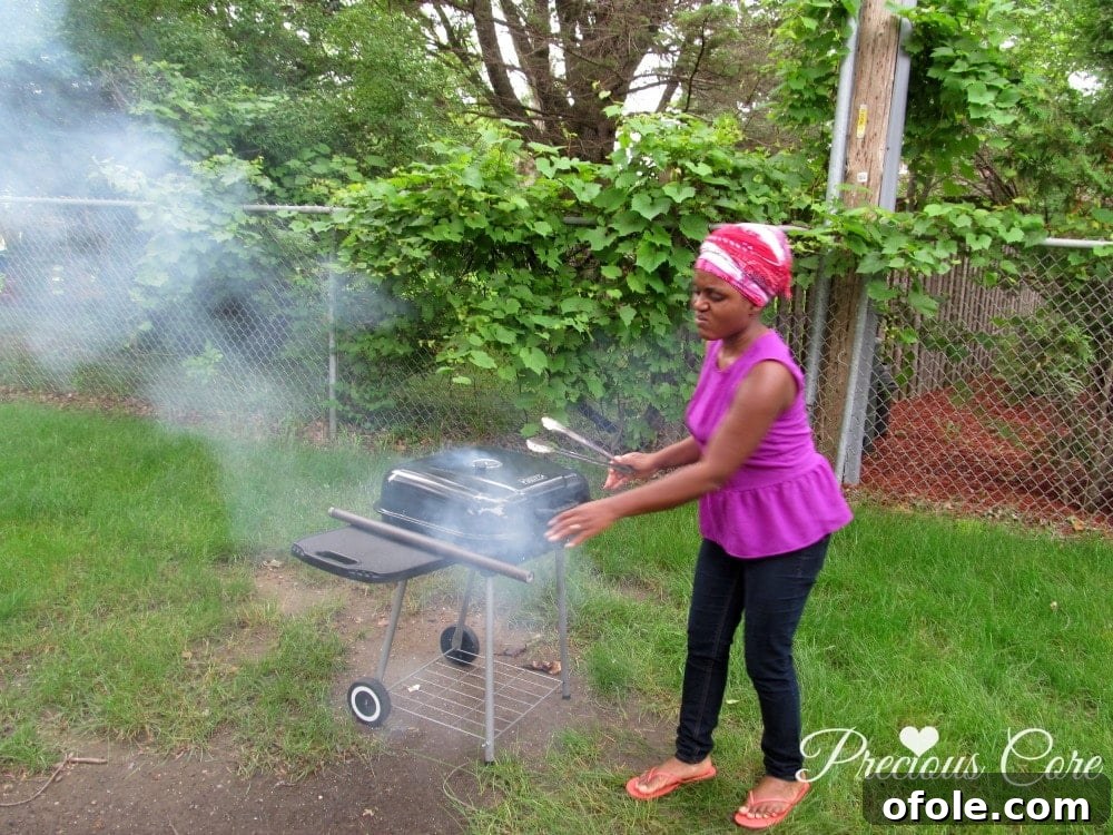Excited cook standing next to a smoking charcoal grill, ready to start cooking