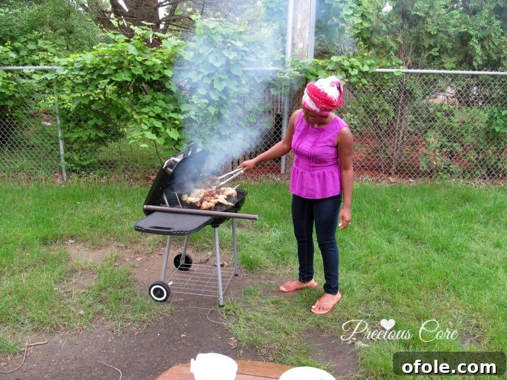 Marinated chicken wings and thighs beautifully arranged on a hot grill, cooking over charcoal