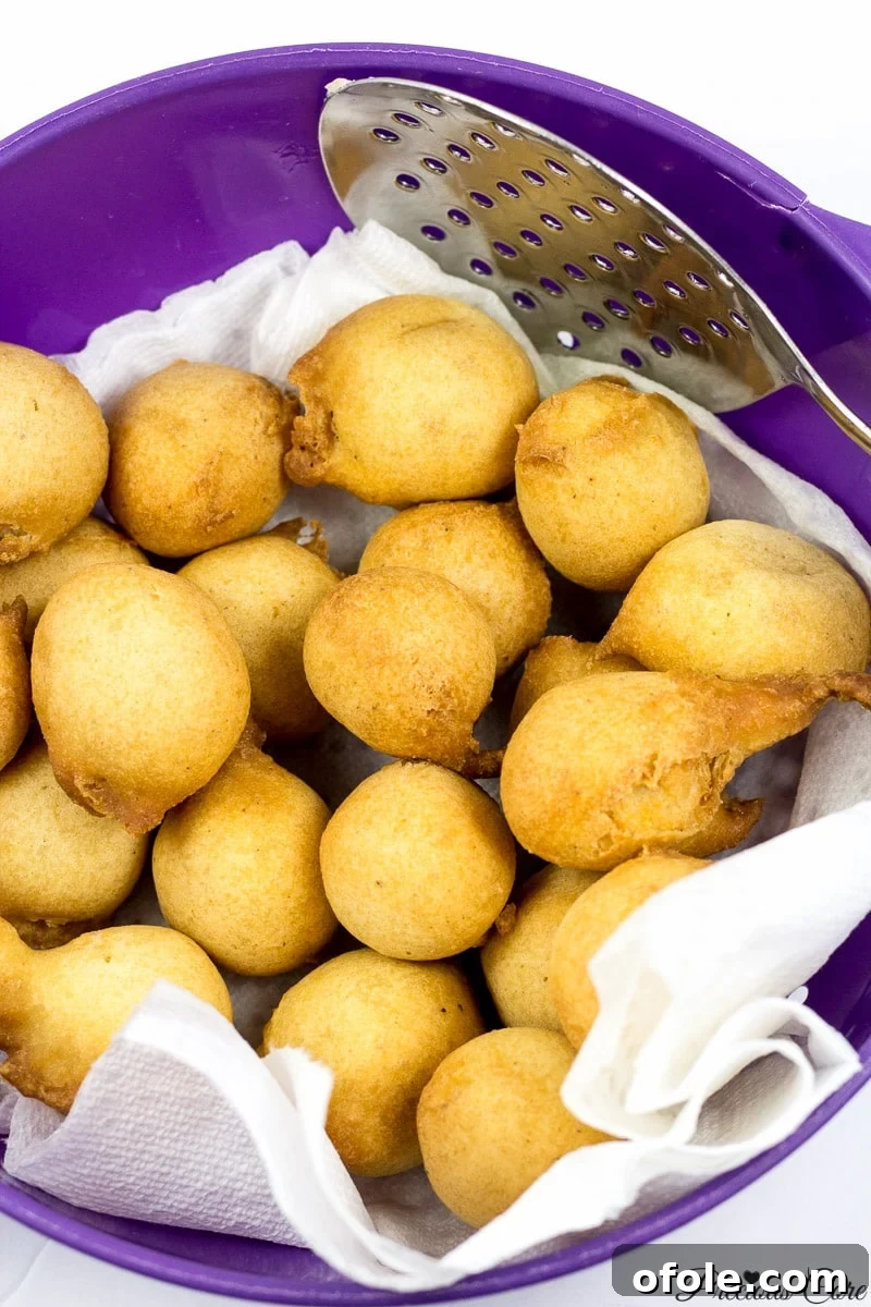 Cameroonian doughnuts on paper towels in a bowl, draining excess oil.