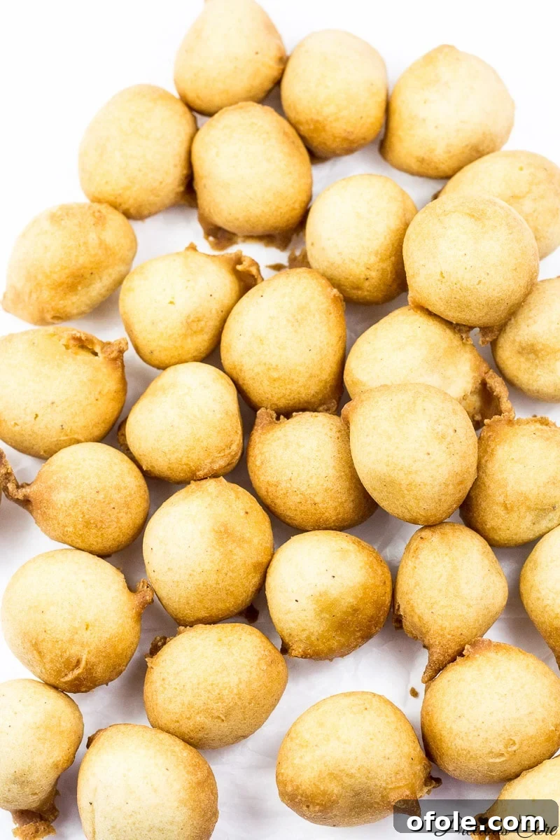 Several golden brown Cameroonian drop doughnuts.