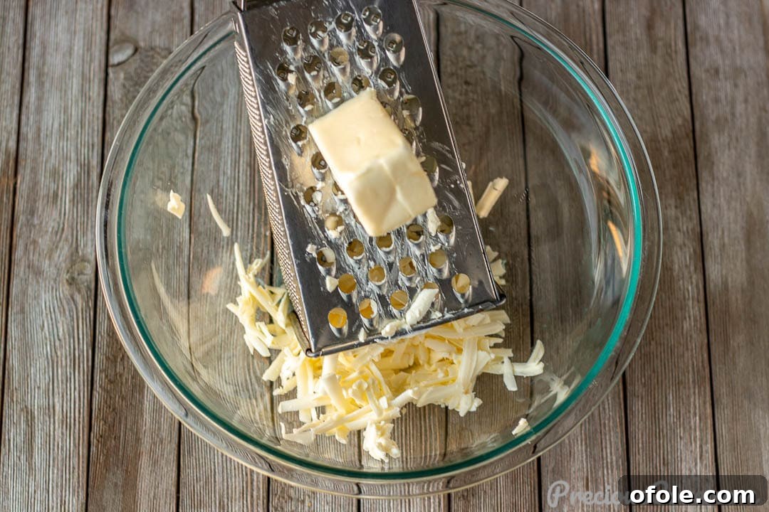 Grated cold butter in a stainless steel mixing bowl, ready for combining with dry ingredients.