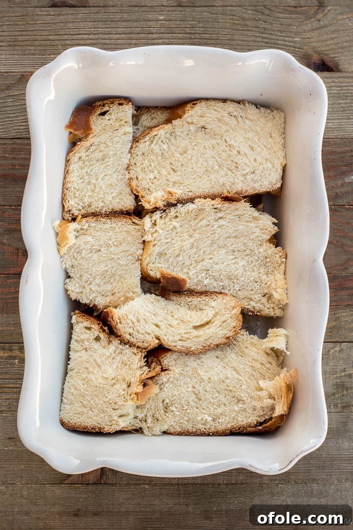 Golden Challah Bread Pudding 5 Arranged slices of Challah bread in a baking pan, ready for the custard mixture