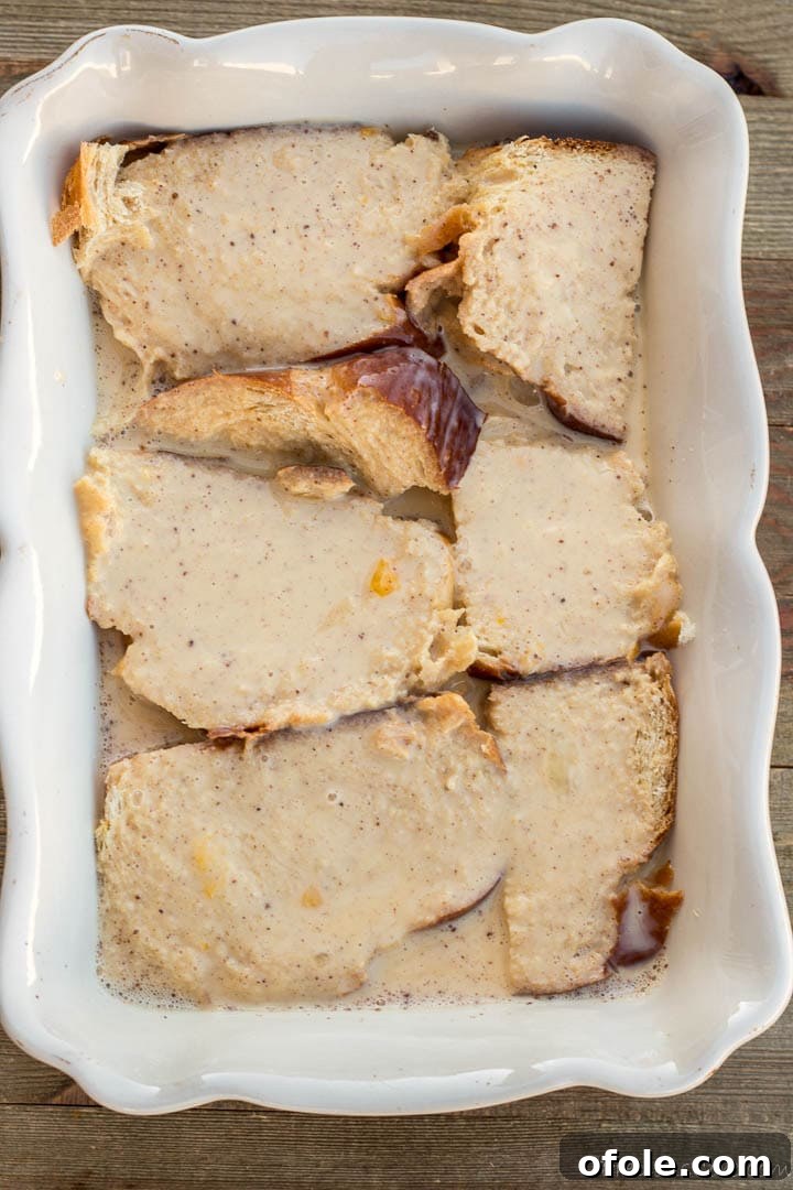Golden Challah Bread Pudding 8 Challah bread slices resting and soaking in the egg milk mixture in a baking dish