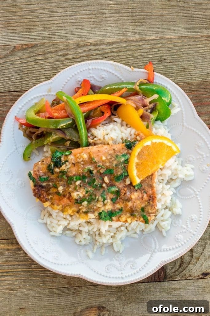 Plate of vibrant sauteed peppers, fluffy white rice, and perfectly baked salmon