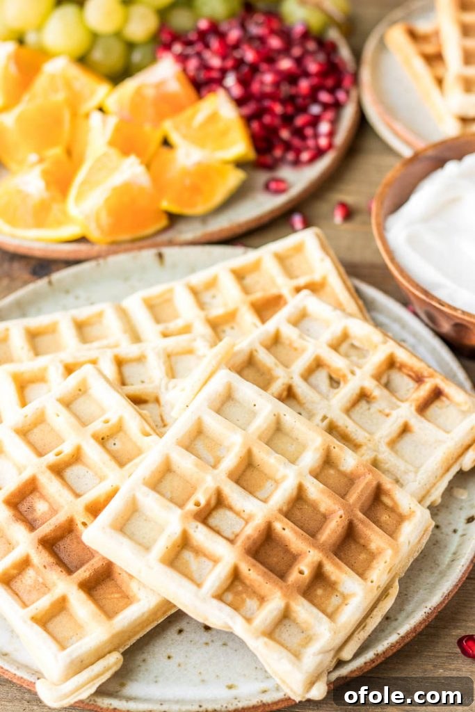 Kitchen-Crafted Waffles 2 Golden brown homemade waffles on a white plate, ready to be served.