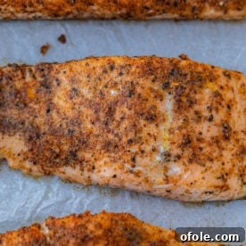 Baked Cajun salmon on parchment paper, perfectly seasoned and cooked.