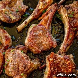 Pan seared lamb chops in a cast iron skillet, golden and herb-crusted.