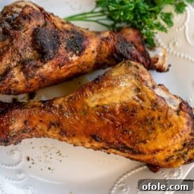 Two Turkey Drumsticks on a plate, golden brown and seasoned.
