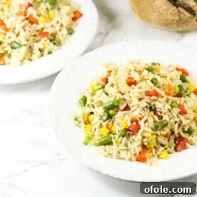 White bowls of fragrant coconut fried rice, garnished with fresh herbs.