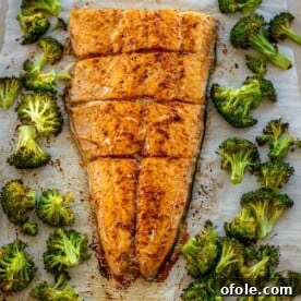 Large salmon fillet and roasted broccoli on a sheet pan, a healthy and easy one-pan meal.