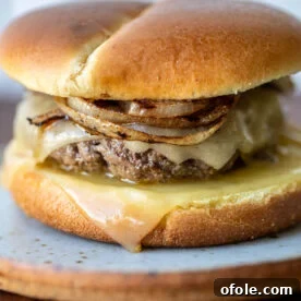 A perfectly grilled onion cheddar burger on a plate, ready to be enjoyed.