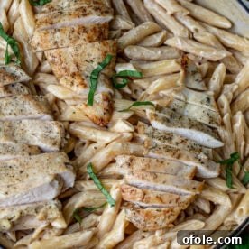 Creamy garlic parmesan pasta topped with tender chicken, a rich and satisfying dish.