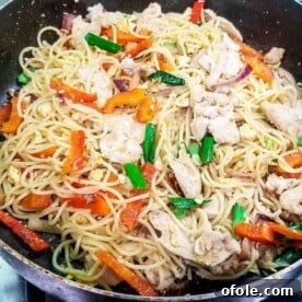 Stir fry with spaghetti and chicken in a pan, a unique and flavorful fusion dish.