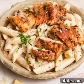 Creamy pasta in a bowl, topped with pan-seared chicken, a quick and elegant dish.