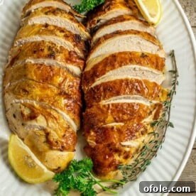2 sliced baked turkey breasts on serving platter, juicy and tender.