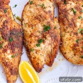 Thin sliced chicken breasts served with lemon wedges, perfectly golden.
