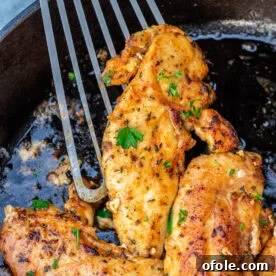 Spatula holding a cooked chicken tenderloin, showcasing its golden color.
