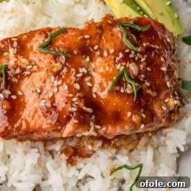 Teriyaki Salmon over rice with avocado slices in a bowl, a vibrant and healthy meal.