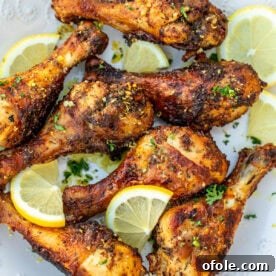 Cooked lemon pepper drumsticks on a white plate, golden and zesty.