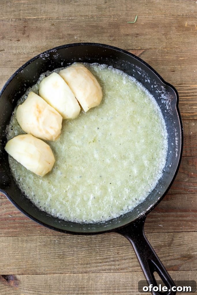 Apple slices over melted butter and sugar
