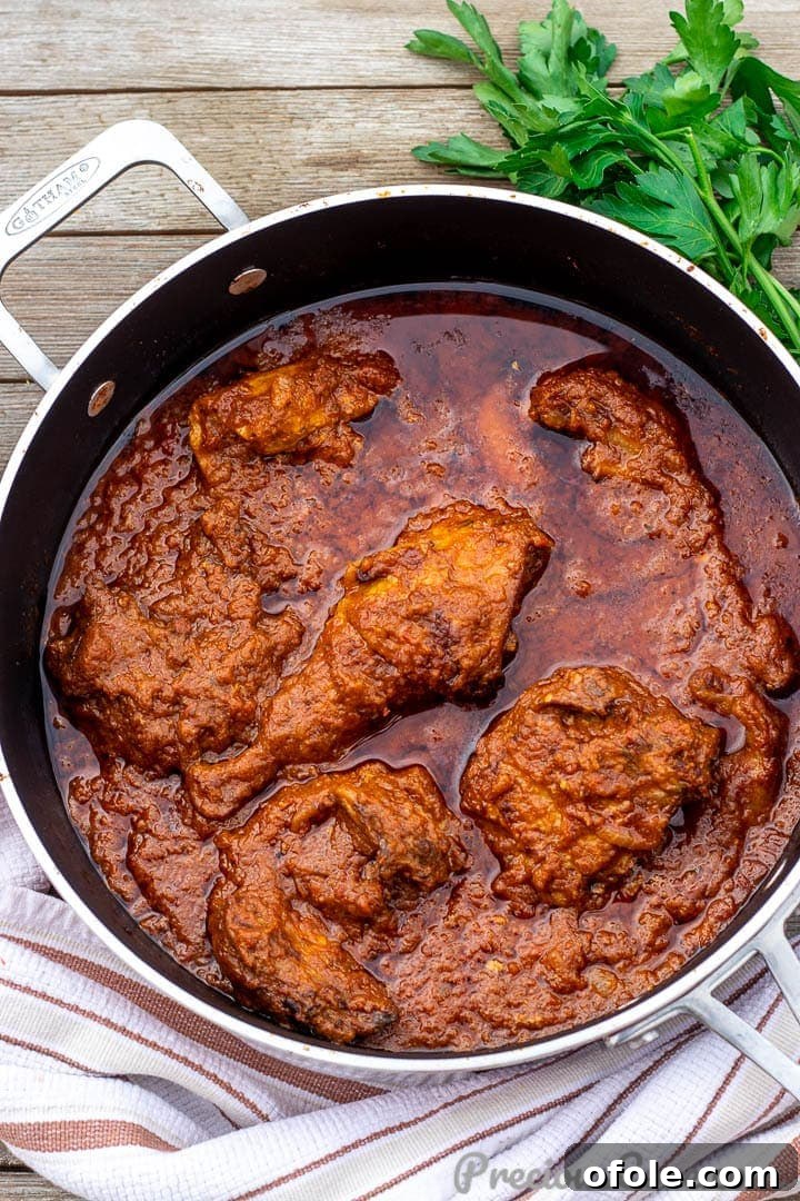 A large pan brimming with vibrant African Chicken Stew, ready to be served.