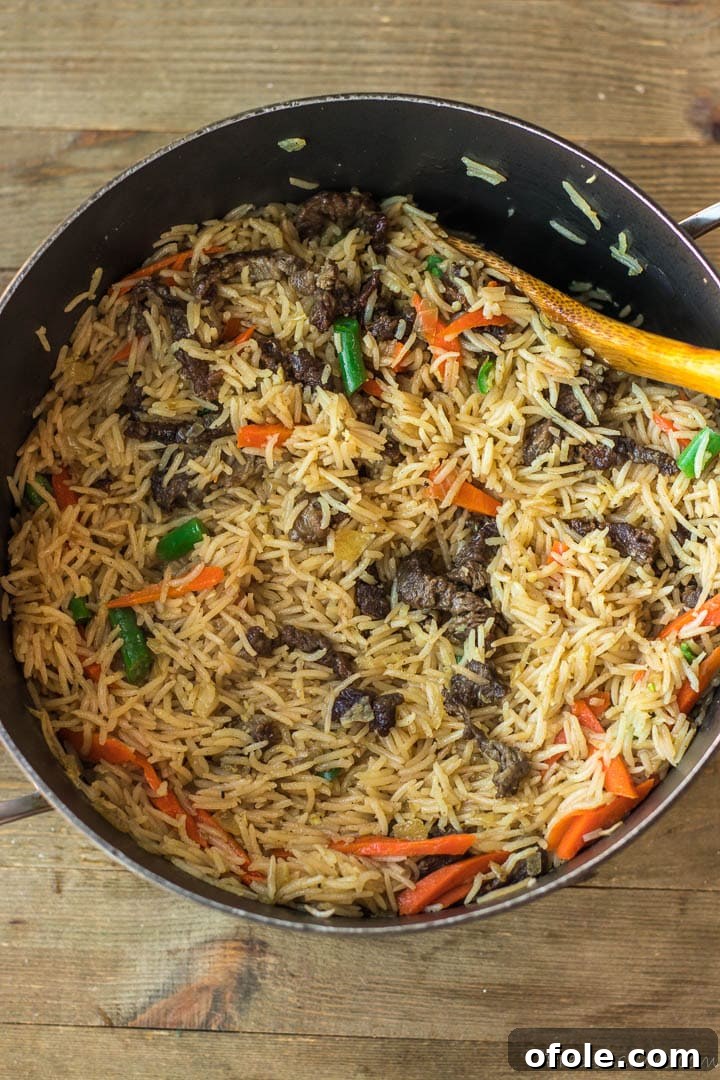 The one-pot Beef Fried Rice with vegetables steaming in the pot.